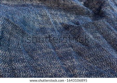 clothing items blue stonewashed faded jeans cotton fabric texture with seams, clasps, buttons and rivets, macro, close-up