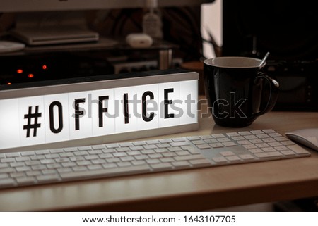 on a white illuminated cinema sign stands with black letters #office