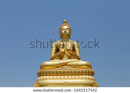 The Buddha statue is a large golden statue in the clear sky in Thailand.