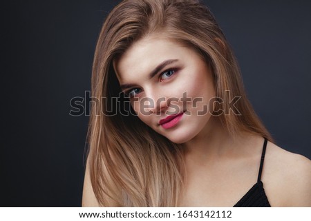 Closeup portrait of beautiful lady with natural makup and smooth healthy skin against dark background