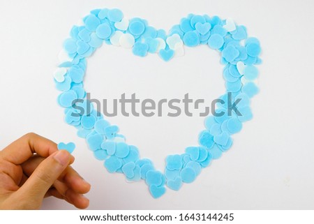 Small white and blue hearts form on a white background. Top view of valentines day symbols