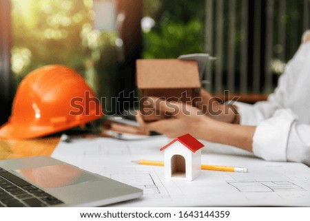 Close up of house model on architect female holding house model background.