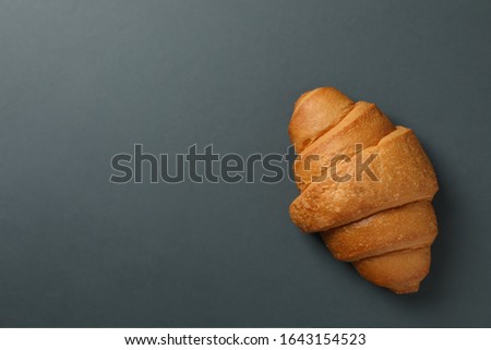 Freshly baked croissant on dark background, top view