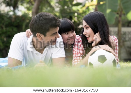 Happy family, Parents, children spend time together on holidays, They play football in front of their home.