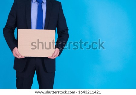 businessman holding an empty poster on blue background