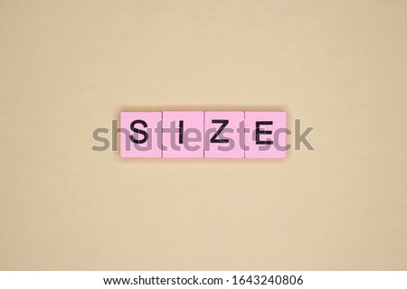 Size word wooden cubes on yellow background.