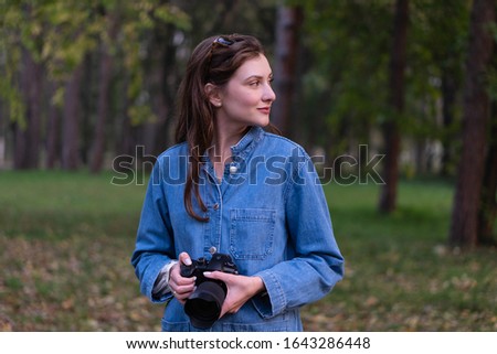 A professional photographer while working outdoors. Autumn Forest, Caucasian woman content creator
