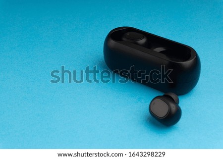 Wireless earbuds or earphones on blue background