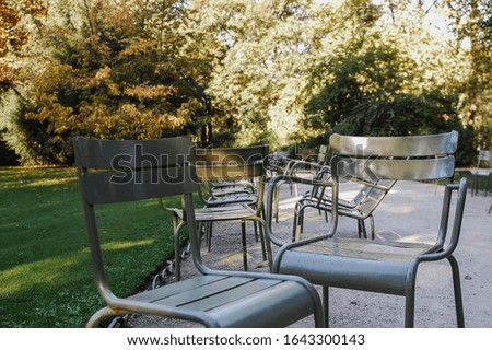 outdoor relax chair with spring natural graden at sunset. surrounded by green trees and leaves near house.