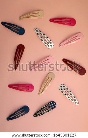 Colorful trendy hair clips on bright pink background. Top view.