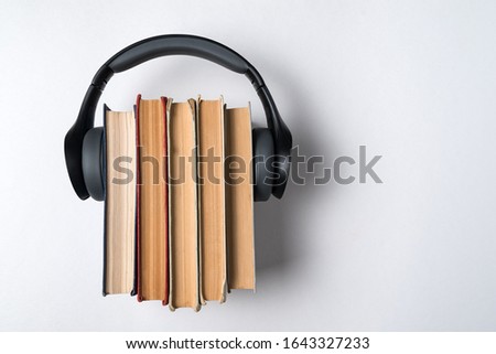 A few old books and headphones on a white background. Audio library concept. Top view.