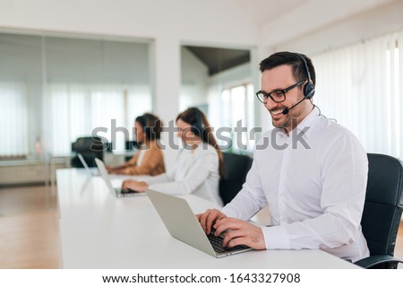 Male customer support phone operator at work, portrait.