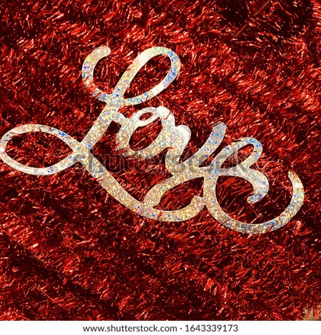 Close view of the word love on a red glitter background - festive Valentine’s Day decoration