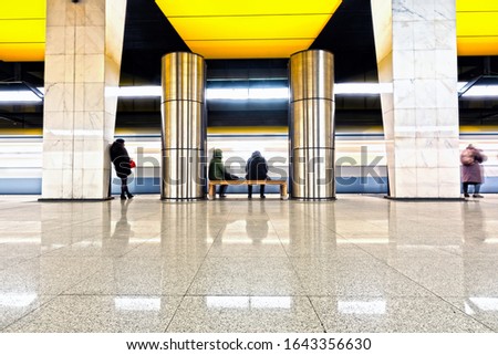 subway train arriving to modern metro station with passengers  waiting on platform abstract blurred background. Side view of city transportation underground station with motion car and people