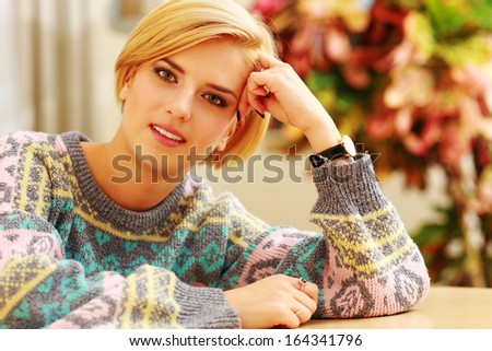 Young beautiful happy woman sitting at the table at home