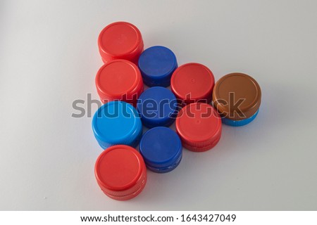 triangle formed by plastic caps of various colors isolated on white background