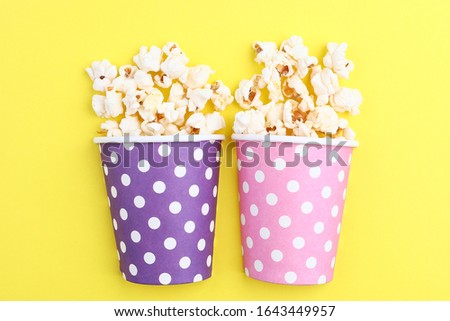popcorn in paper cups on a colored background