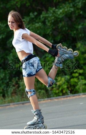 Beautiful teenage girl rollerskating in park