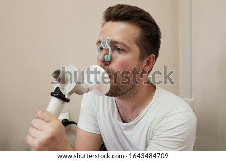 Young man testing breathing function by spirometry having health problem. Royalty-Free Stock Photo #1643484709