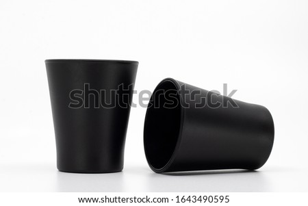 Blank mockup cups isolated on white. Two black shot glasses. Matte glass kitchenware. Empty cups or containers. Royalty-Free Stock Photo #1643490595