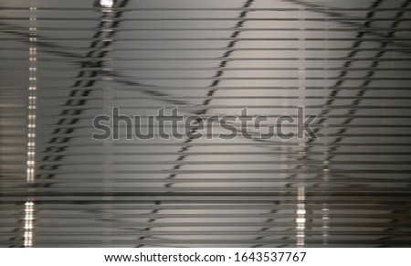 Blur ripple glass texture. Modern architecture with steel framework of roof girders. Abstract office or industrial building fragment with transparent stripy geometric structure of parallel lines.