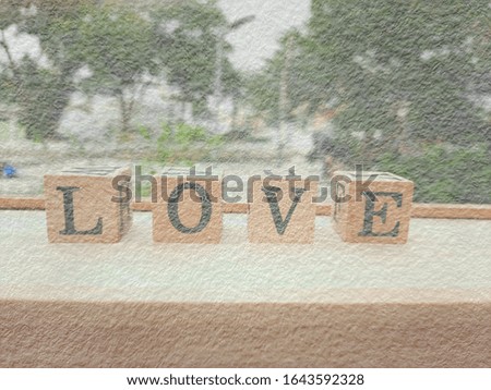 The image of square wooden blocks with four letters LOVE isolated on a wooden box, shot with blur mode for decorative design and Valentine's day.