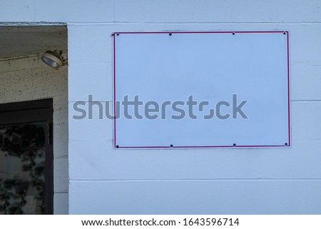Blank white sign on a white cinder block wall