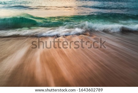Scenic seascape. Silky milky foam waves at sandy beach. Sunset time. Waterscape for background. Slow shutter speed. Soft focus. Motion blur. Sunlight reflection on the water. Bingin beach, Bali