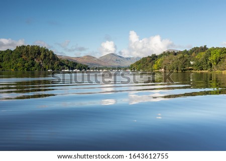 Gentle boat waives on Loch Lomond with Balmaha Boat Yard in the background, Scotland Royalty-Free Stock Photo #1643612755