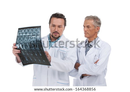Two experienced doctors discussing X-ray. Standing isolated on white 