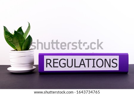 regulations the office folder lies on a dark table with a flowerpot and flower on a light background