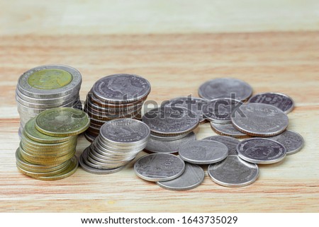 Thai baht coins on wood grain background detail object blur