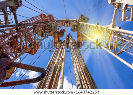 Oil and Gas Drilling Rig onshore dessert with dramatic cloudscape. Oil drilling rig operation on the oil platform in oil and gas industry Royalty-Free Stock Photo #1643742253