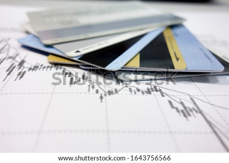 Bank cards are stacked on the K-line chart