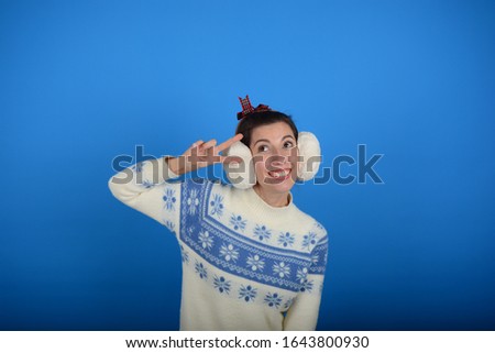 woman smiles signs with fingers on a blue background