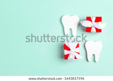 Teeth and gift boxes on a blue background. Happy Dentist's Day concept.