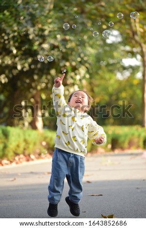 A little boy who jumped up and touched bubbles with his fingers