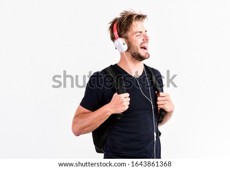 Student handsome guy listening music. Youth music taste. Modern people concept. Man tousled hairstyle wear plastic earphones gadget. Enjoy music everywhere you go. Download music application.
