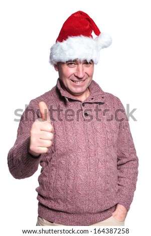 senior casual man in santa hat is making the ok thumbs up hand sign on white background