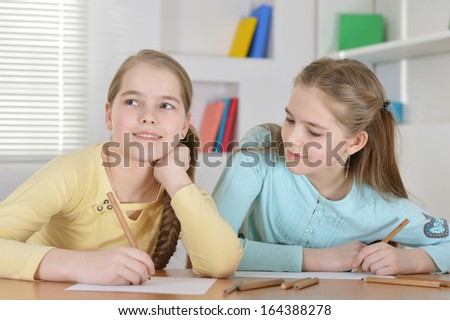 Young twins drawing together at the table at home