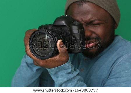 African-American photographer on color background