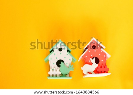 Top view lovely small decor easter house in pink red and green pastel on yellow background. Easter and spring background concept.