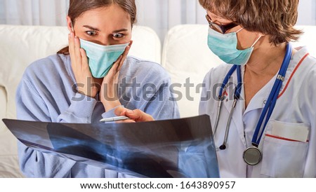 doctor and young patient examine x-ray of lung and discuss treatment strategy, concept of confronting coronavirus pandemic