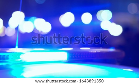 Flashing lights of a police flasher on the roof of a police car at night