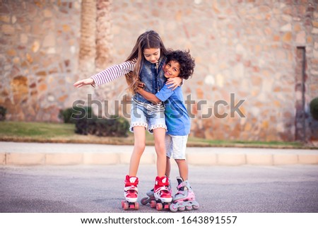 Two happy kids boy and girl roller skate in the park. Children, lifestyle and activity concept