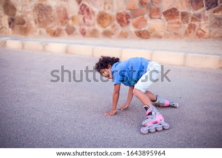 A kid boy on rollerskates fell down and feels pain. Children, leasure and healthcare concept