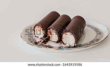A Hungarian dessert called "Túró Rudi" on a Herend porcelain plate. The inside is cottage cheese (curd) and the coating is chocolate. Royalty-Free Stock Photo #1643919586