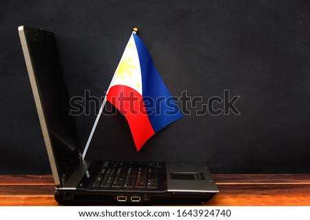  flag of Philippines , computer, laptop on table and dark background