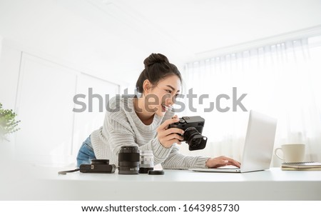 Portrait beautiful asian photographer creative woman working in office holding camera laptop. Business people employee freelance online marketing. Successful freelance creative artist girl business.