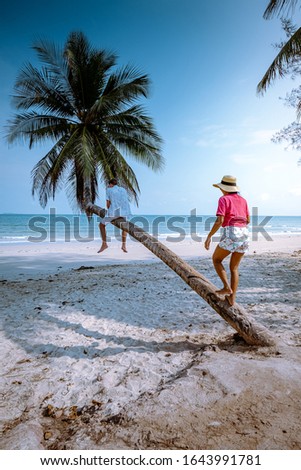 Wua Laen beach Chumphon area Thailand, palm tree hanging over the beach with couple on vacation in Thailand